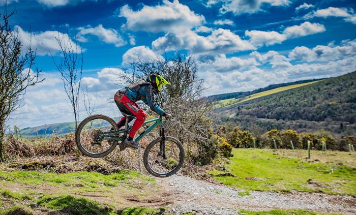 A younger rider jumping on one of the trails.